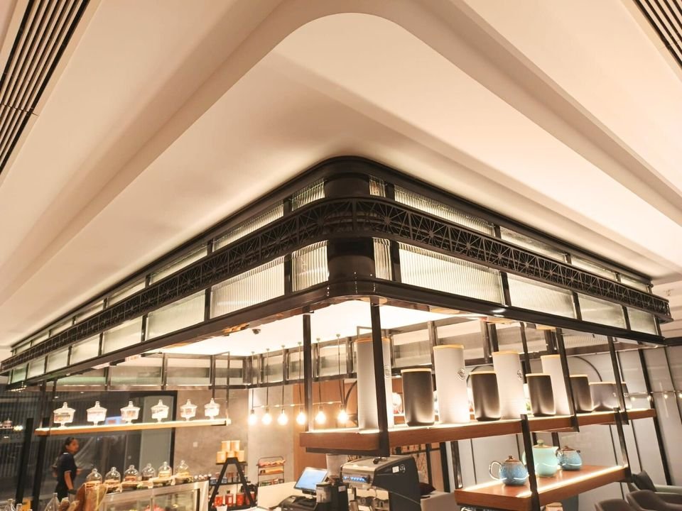 Coffee counter with a black metal canopy and display shelving