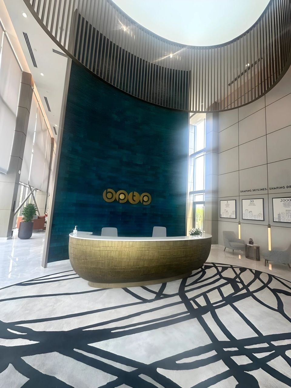 Lobby with a curved desk and teal feature wall