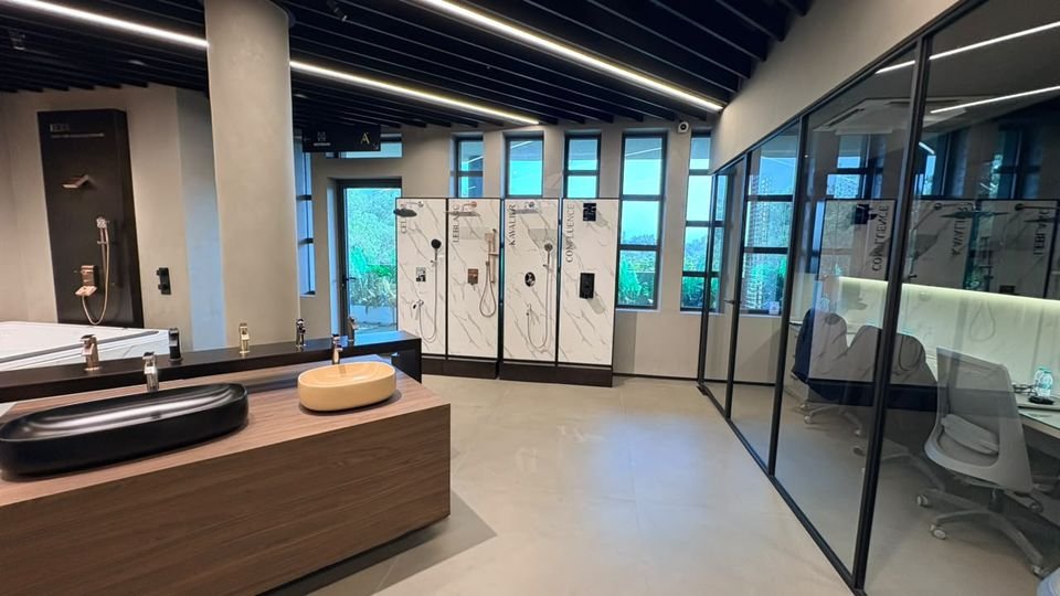 Vanity island & shower panels. A timber vanity island with black and timber-tone vessel basins, shower panels and a glazed office behind.