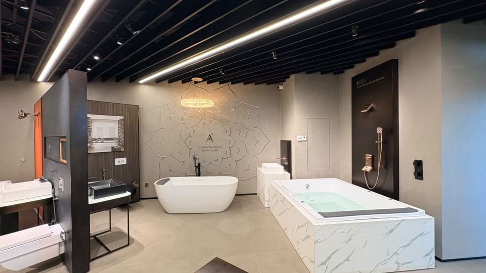 Mandala relief wall. A freestanding bath, a marble-clad bath and a crystal chandelier before a mandala relief wall.