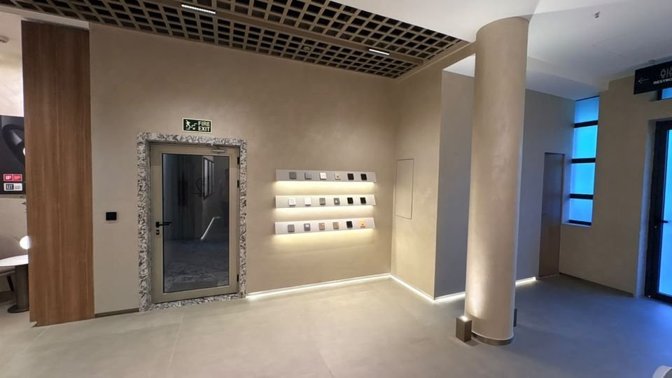 Switch & controls display. Illuminated shelves of switch plates beside a stone-framed doorway and uplit columns.