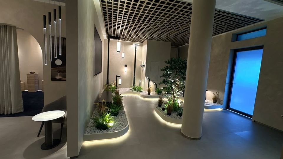 Planted lighting walk. A pendant cluster, bollards and cove-lit planters around a column.