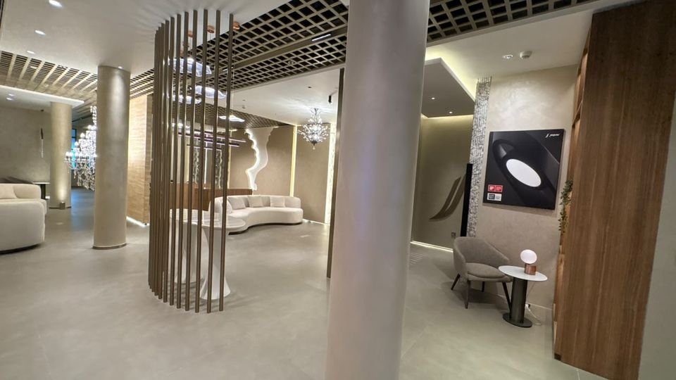Slatted screen & display. A curved timber-slat screen, lounge seating and a lighting product panel.