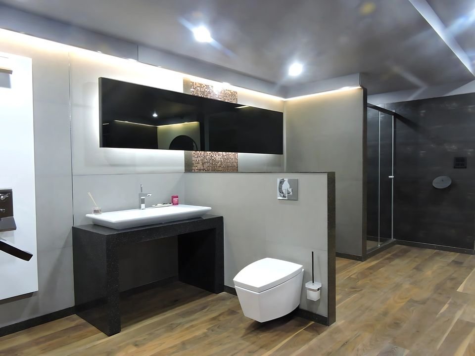 Dark-toned bathroom vignette with timber flooring and a wall-hung WC