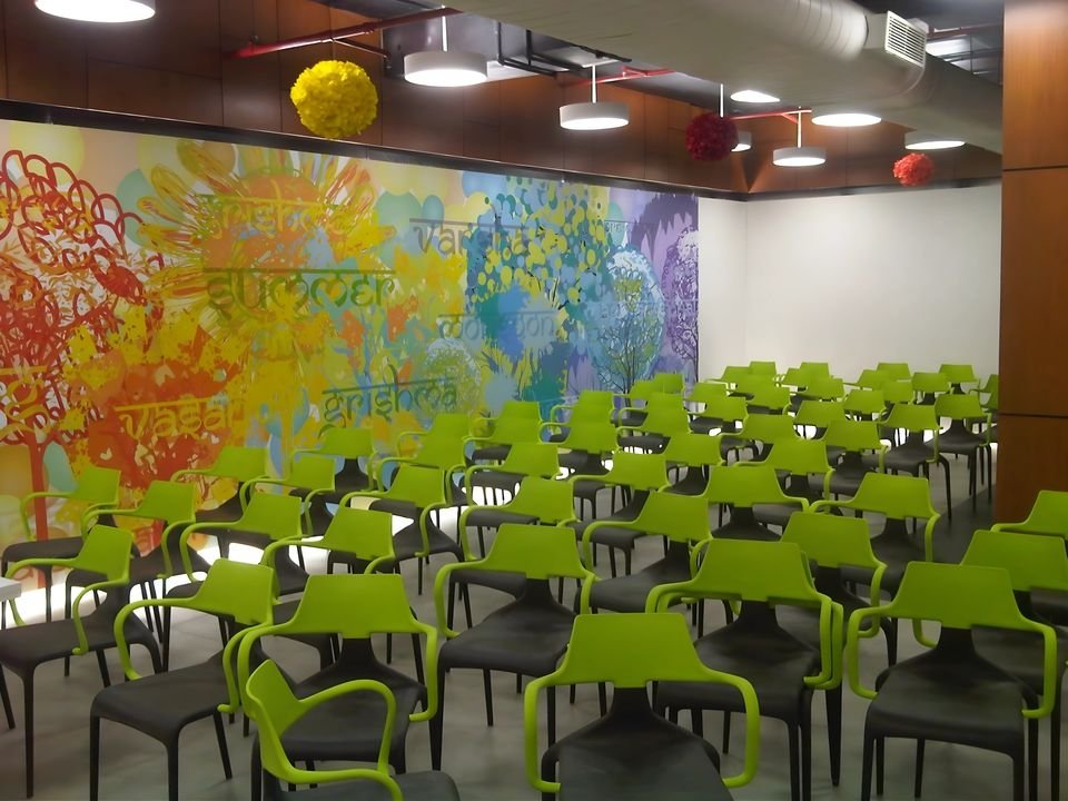 Cafeteria with lime-green chairs and a painted mural wall