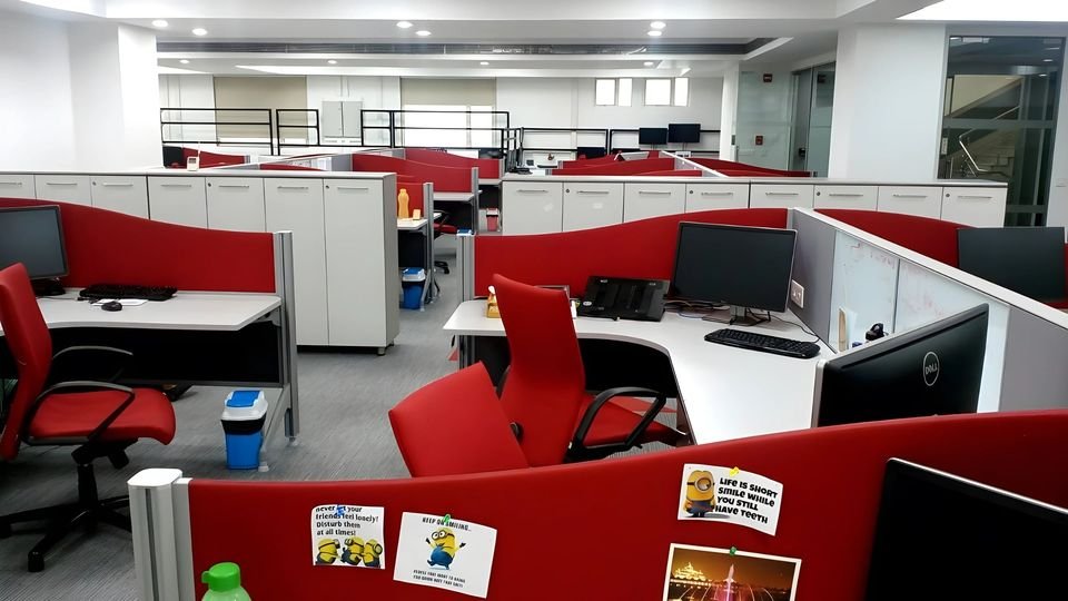 Open-plan workstations with red screens